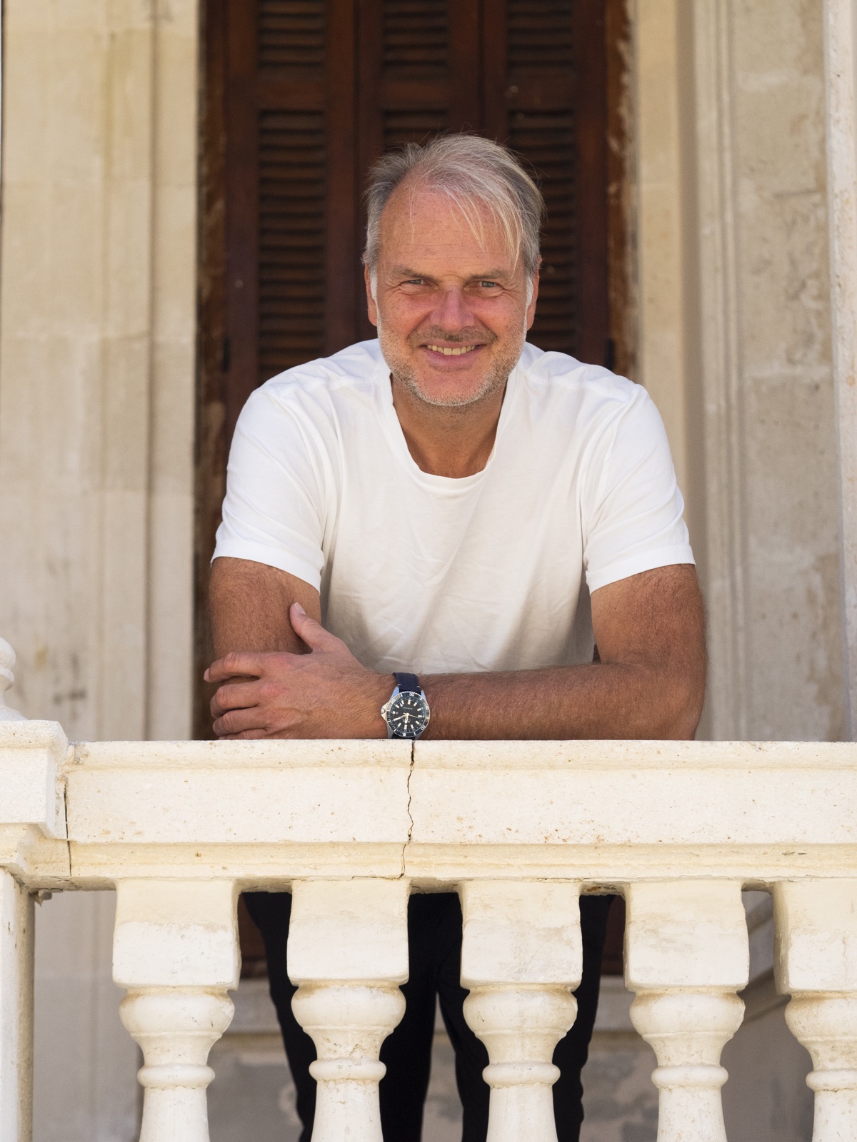 Dr. Ronald Kandelhard auf einem Balkon in Mallorca, weißes T-Shirt